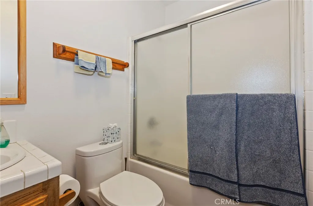 Second bathroom with enclosed tub shower combination.