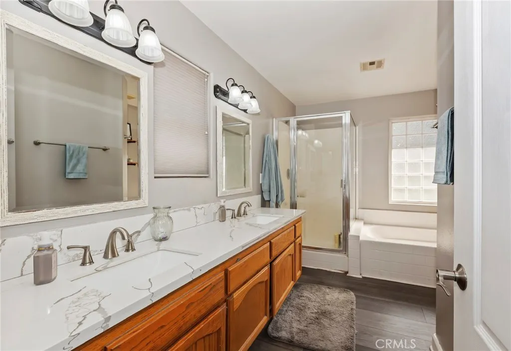 Primary bath with dual sinks set in quartz countertop. Seperate shower and tub.
