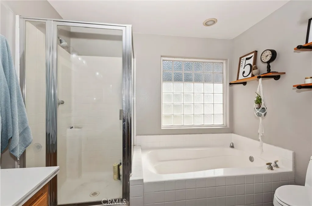 Large soaking tub with glass block window. Seperate enclosed shower.