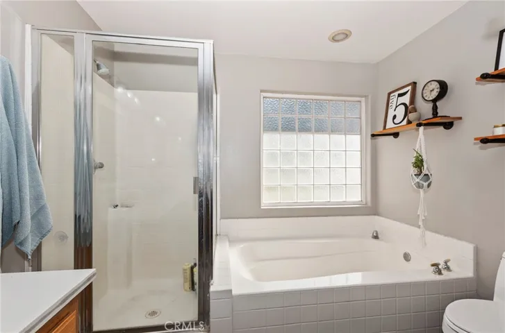 Large soaking tub with glass block window. Seperate enclosed shower.