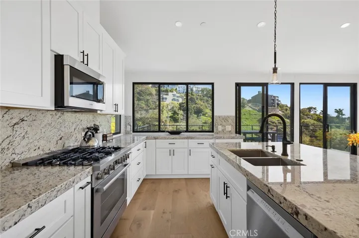 The chef’s kitchen is both functional and refined, featuring stone countertops, custom cabinetry, and a center island with charming breakfast seating.