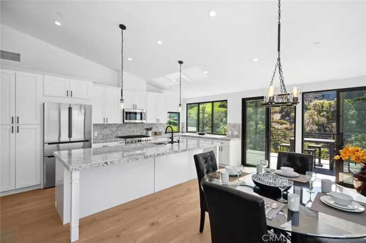 Inside, a beautifully arranged dining, kitchen, and family area is designed for both elegance and ease.