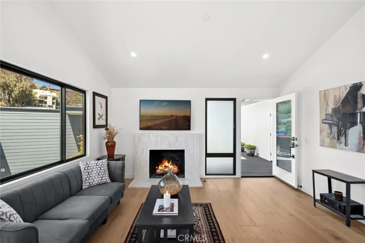 Vaulted ceilings and brand-new Milgard windows frame sweeping views, extending from the fireplace-warmed living room to the coastal-view dining space—an ideal setting for entertaining.