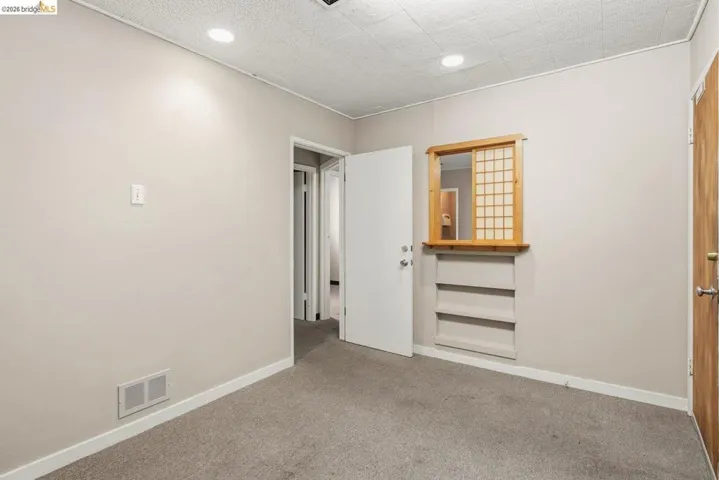 Unfurnished bedroom with light carpet and recessed lighting