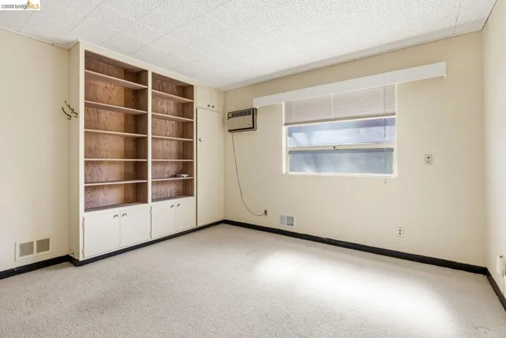 Unfurnished bedroom with light colored carpet and baseboards