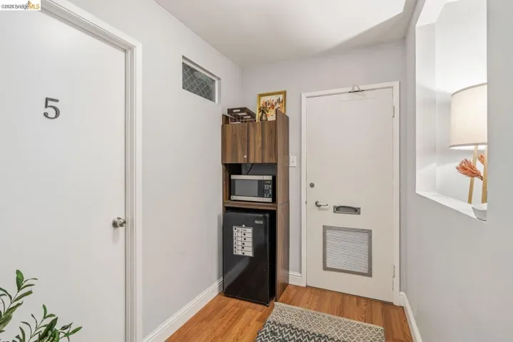 Doorway to outside with wood finished floors and baseboards