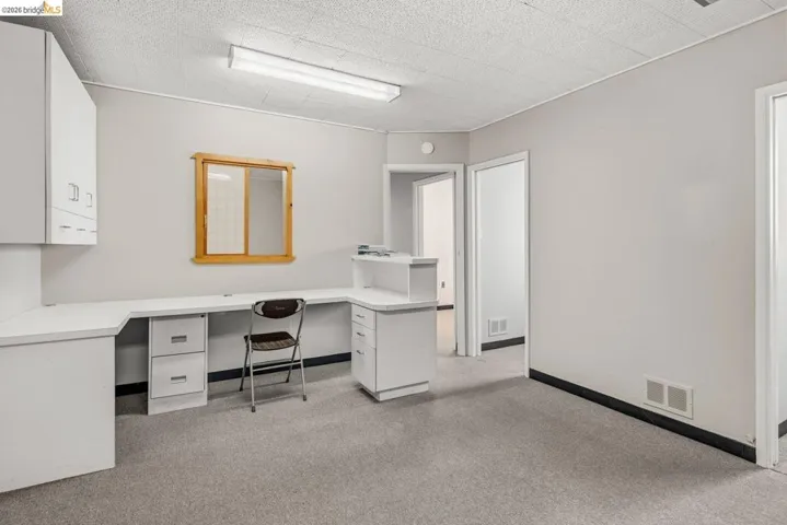 Office space with light carpet and baseboards