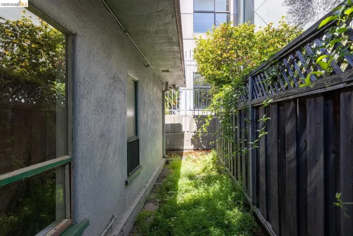 View of side of property featuring stucco siding and a fenced backyard