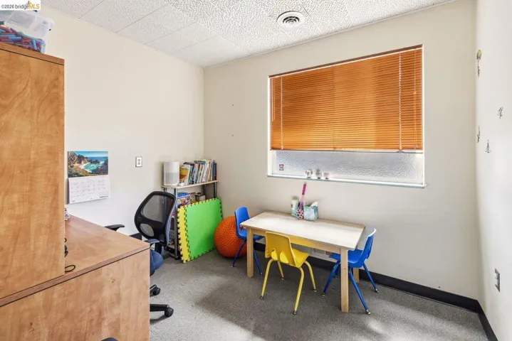 Office area featuring light carpet and baseboards
