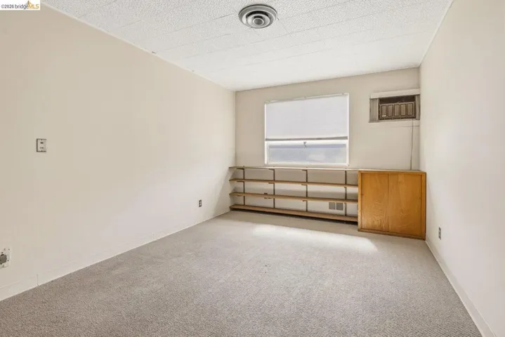 Spare room with light carpet and a wall mounted air conditioner