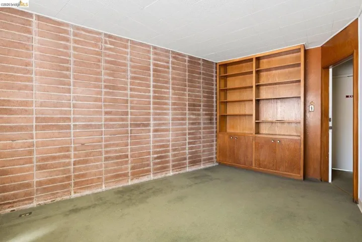 Empty room with built in features and carpet floors