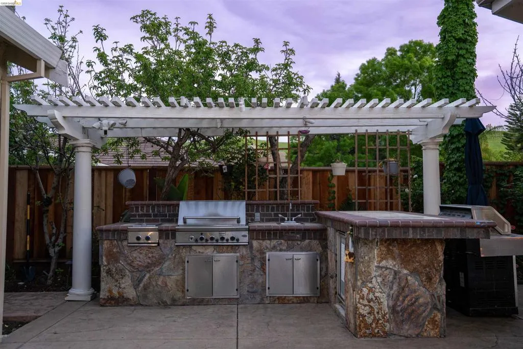 Fenced backyard featuring a pergola, a patio area, and area for grilling