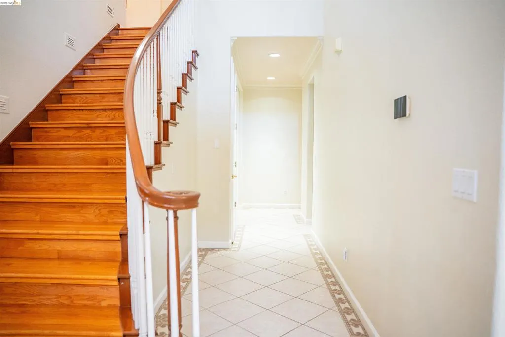 Stairs featuring tile patterned flooring, recessed lighting, and crown molding