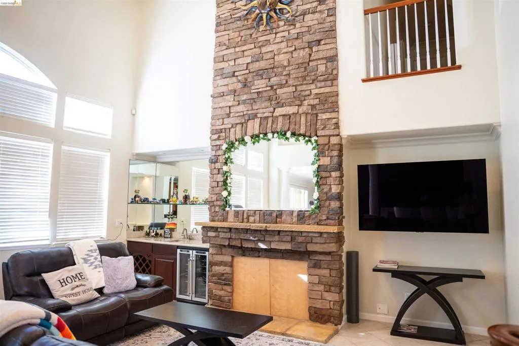 Living area with wet bar, wine cooler, a high ceiling, and tile patterned floors