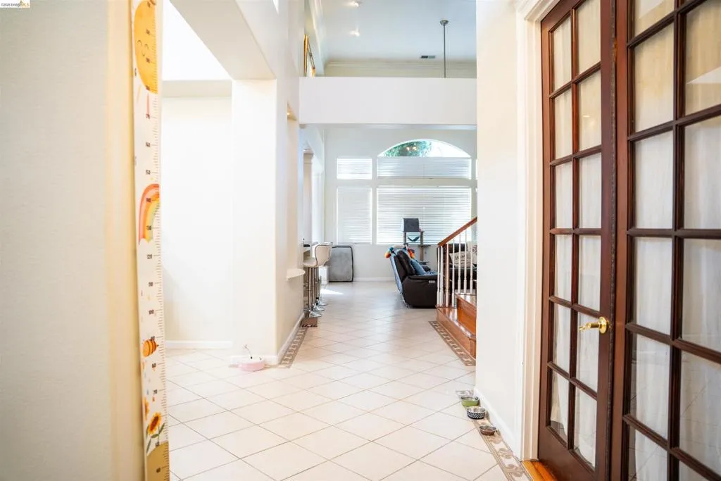 Hall featuring light tile patterned floors and ornamental molding