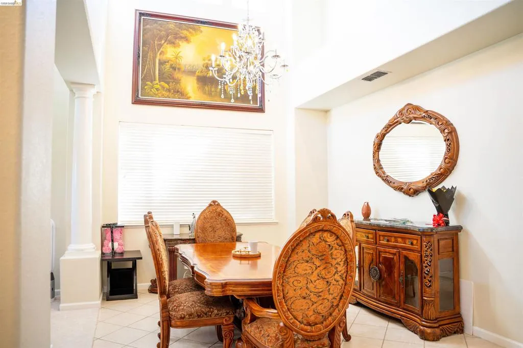 Dining room featuring decorative columns, suspended lighting, and light tile patterned floors