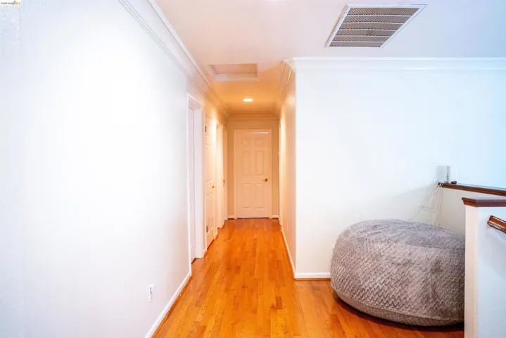 Hall featuring light wood-type flooring and ornamental molding