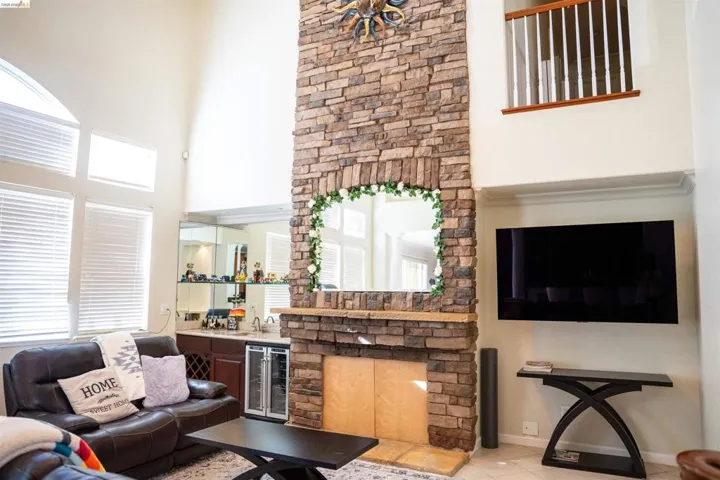 Living area with wet bar, wine cooler, a high ceiling, and tile patterned floors