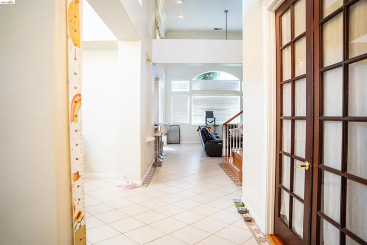Hall featuring light tile patterned floors and ornamental molding