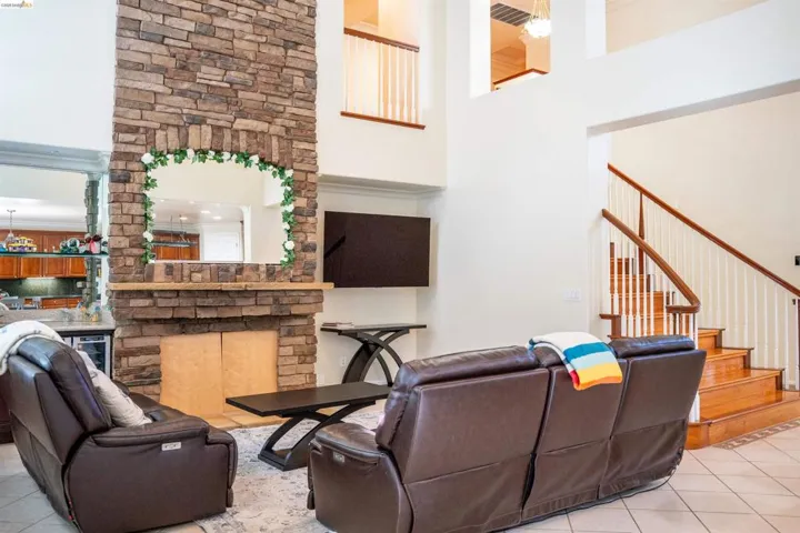 Living room featuring light tile patterned floors, a high ceiling, and beverage cooler