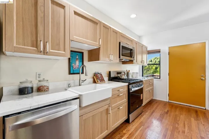 Kitchen with stainless steel appliances, light wood-style floors, light wood finish cabinetry, light stone countertops, and recessed lighting