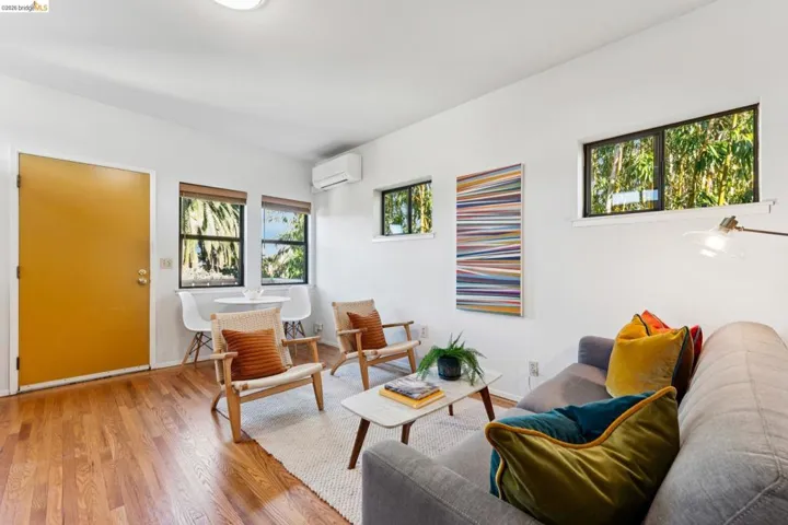 Living room with wood finished floors and a mini split for heating / cooling