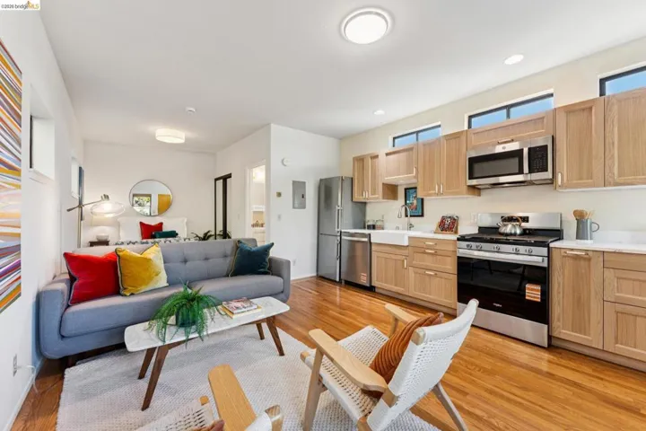 Kitchen with open floor plan, stainless steel appliances, light wood-style flooring, light wood finish cabinetry, and recessed lighting