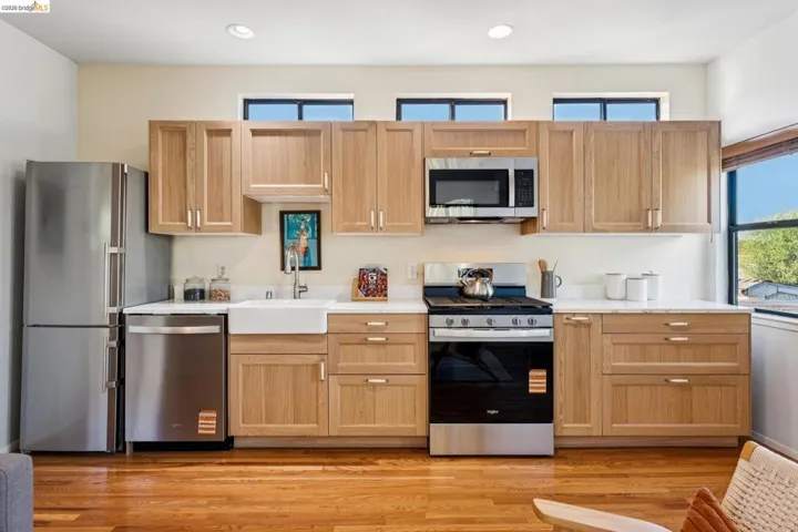 Kitchen featuring stainless steel appliances, light stone countertops, light wood finished floors, recessed lighting, and light wood finish cabinetry