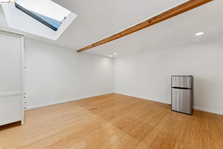 Empty room with Bamboo flooring, a skylight, and recessed lighting.