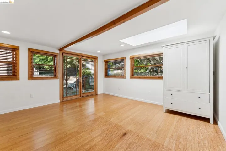 Unfurnished room featuring a skylight and bamboo wood floors.