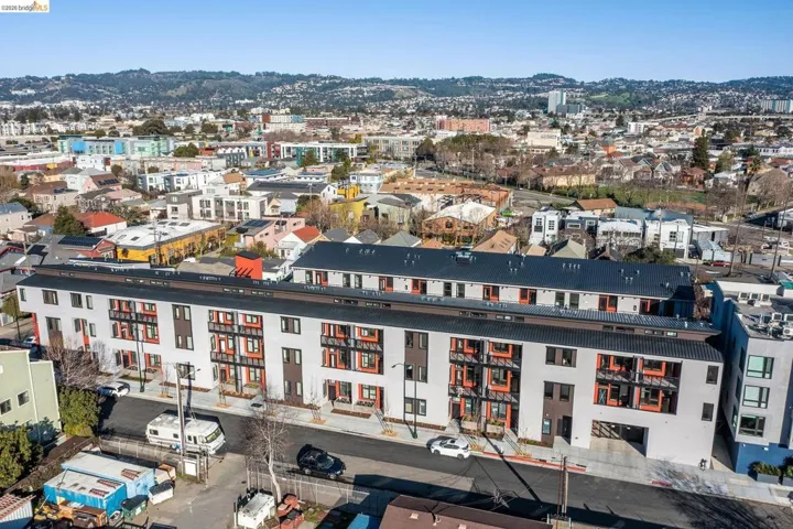 Contemporary multi-level building featuring a flat roofline and integrated balconies with orange accents