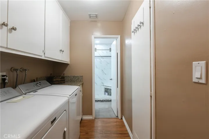 Indoor laundry room with upper cabinets