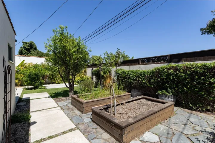 opposite view of backyard raised vegetable beds behind garage