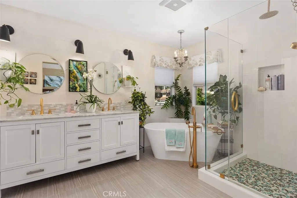 Remodeled primary bath with soaking tub and shower. Marble counter tops on vanity.