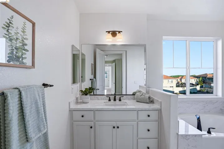 Full bath with vanity and a bath