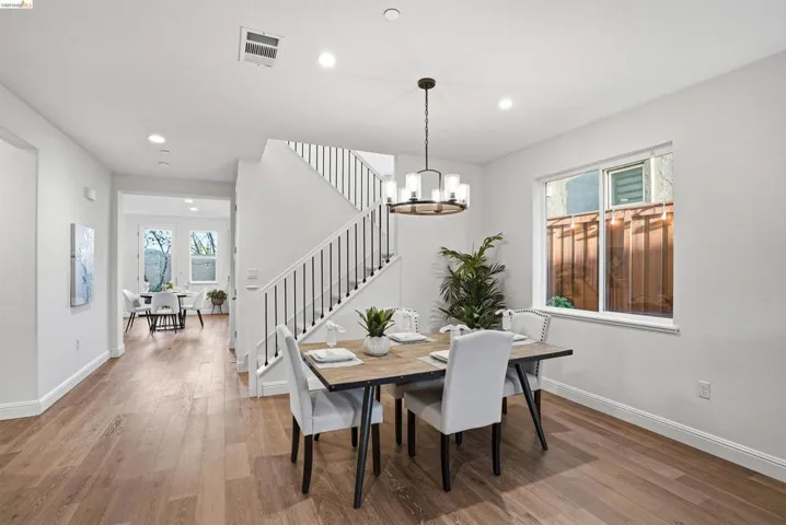 Dining room featuring light wood-style floors, plenty of natural light, and a chandelier