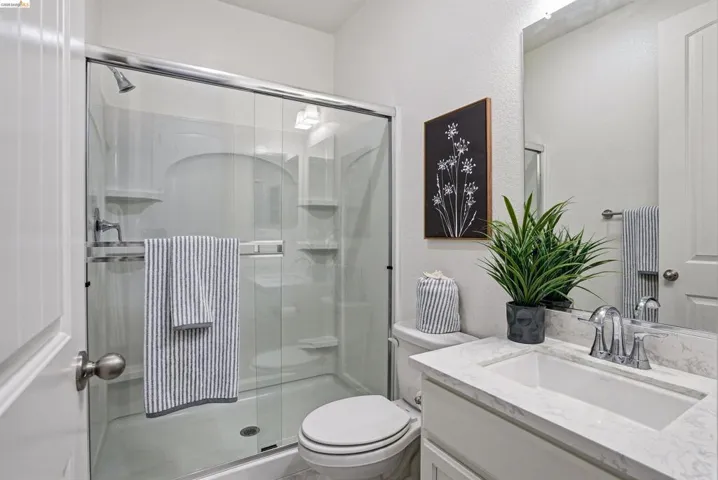 Bathroom featuring vanity, a shower stall, and a textured​​‌​​​​‌​​‌‌​​‌​​​‌‌​​​‌​​‌‌​​‌‌​​‌‌​​​​ wall