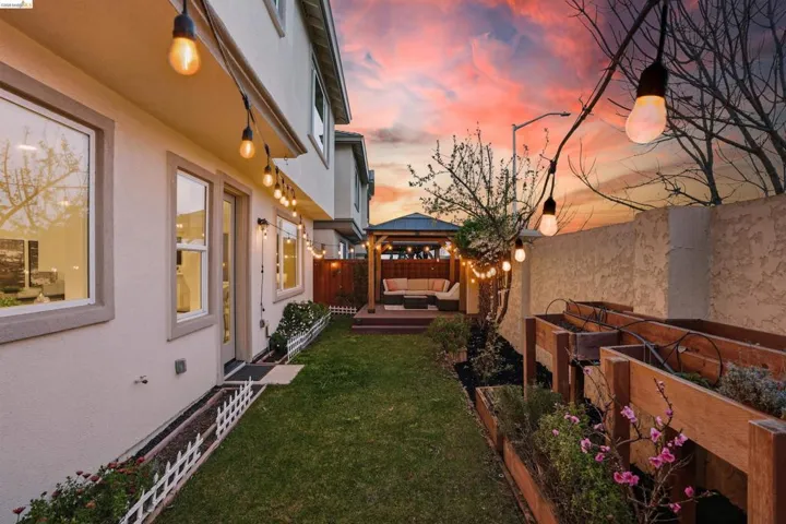 Fenced backyard featuring a gazebo, a deck, outdoor lounge area, and a vegetable garden