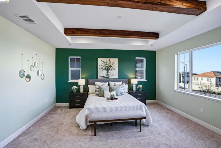 Carpeted bedroom with beamed ceiling and baseboards