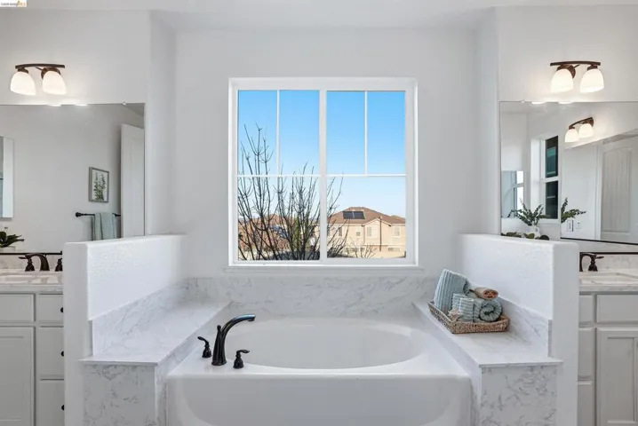 Full bathroom with vanity and a garden tub
