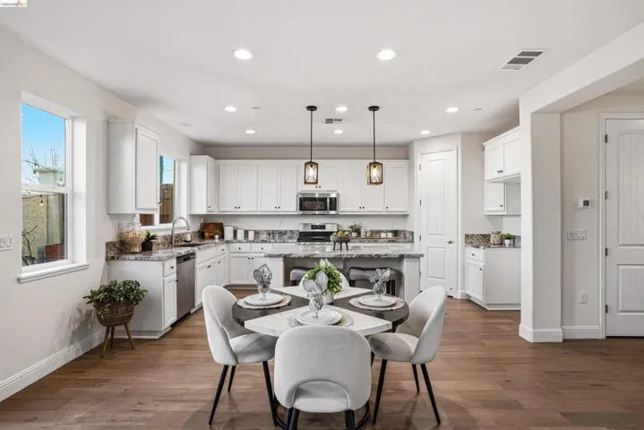 Dining room with dark wood finished floors and recessed lighting