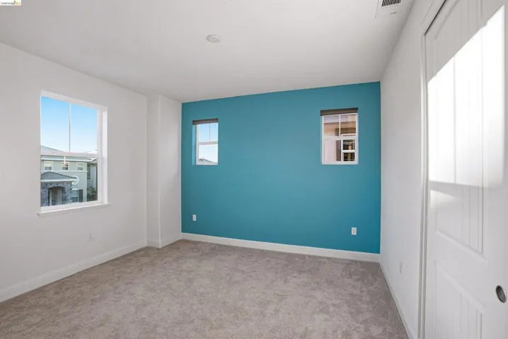 Unfurnished room with light carpet and baseboards