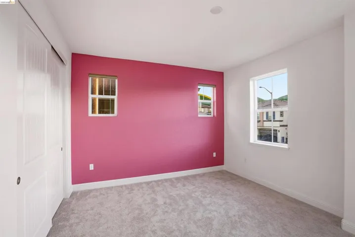 Unfurnished bedroom with light colored carpet and a closet