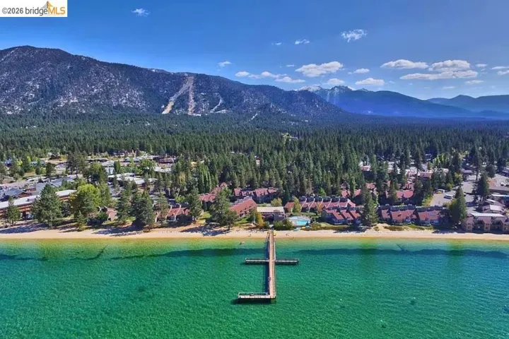 Aerial perspective of suburban area featuring a heavily wooded area and a water and mountain view