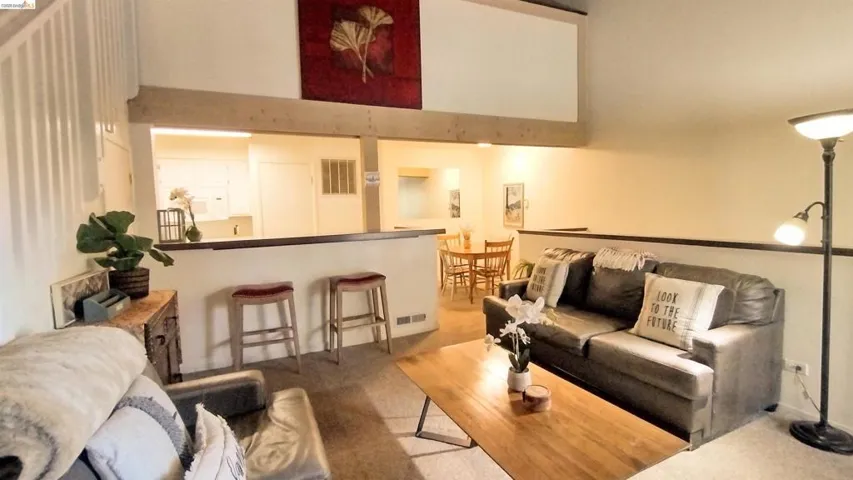 Living room with light colored carpet and a high ceiling