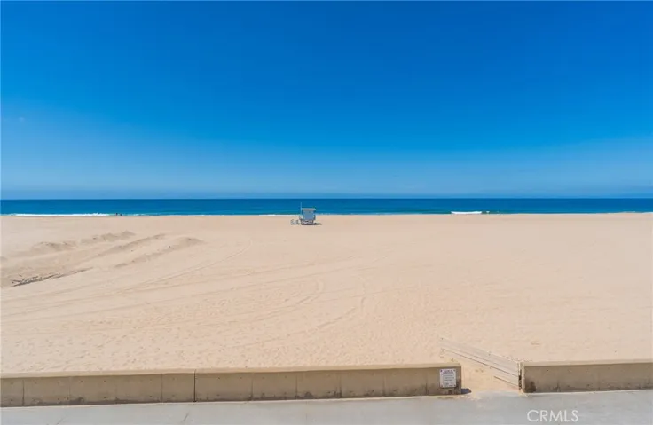 Unobstructed ocean views from the primary bedroom overlooking the wide sandy beach and coastline.