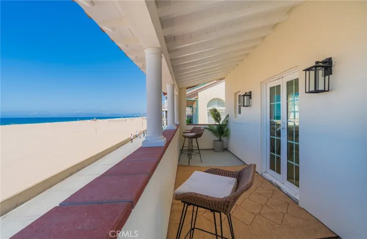Spacious oceanfront balcony off the primary bedroom with panoramic coastline views. A comfortable retreat to relax and take in the beachside setting.