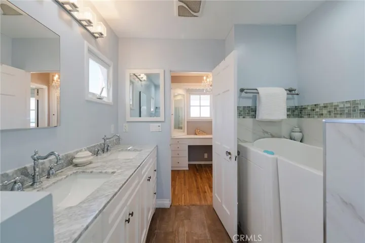 Dual-sink vanity for easy getting ready, with a dedicated makeup area and closet just ahead—conveniently connected to the primary bedroom.
