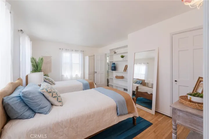 Spacious, light-filled bedroom with two twin beds (convertible to a king), ample storage, and a bright coastal feel—perfect for a comfortable beach stay.