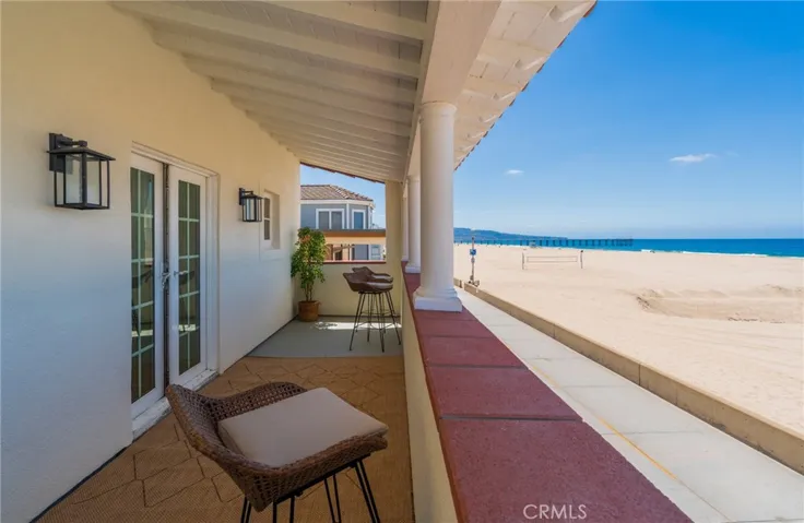 Private oceanfront balcony off the primary bedroom with sweeping beach and pier views—perfect for relaxing and enjoying the coastal breeze just steps from the sand.